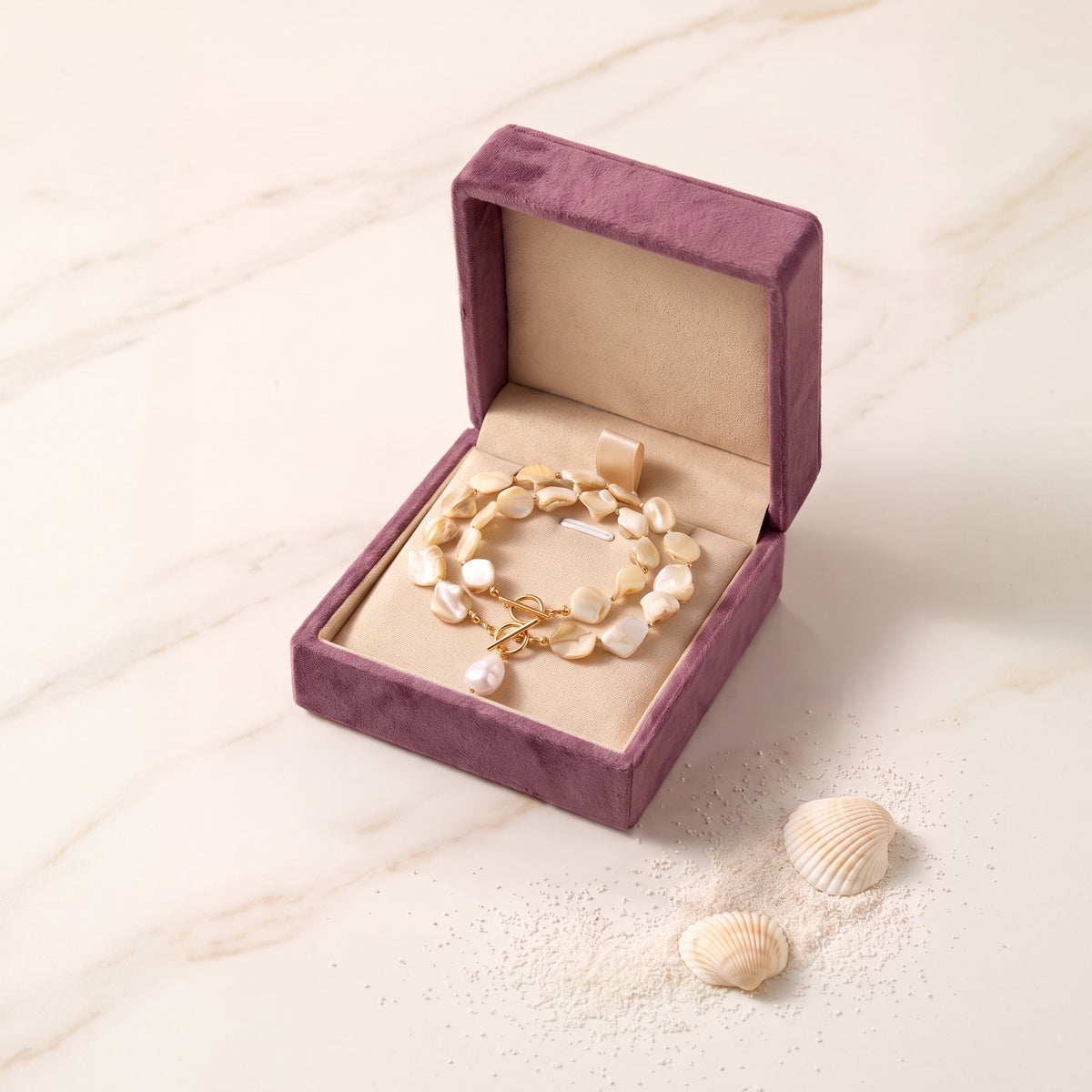 The Ariel Sand Pearl necklace in the Storyelle plum velvet gift box