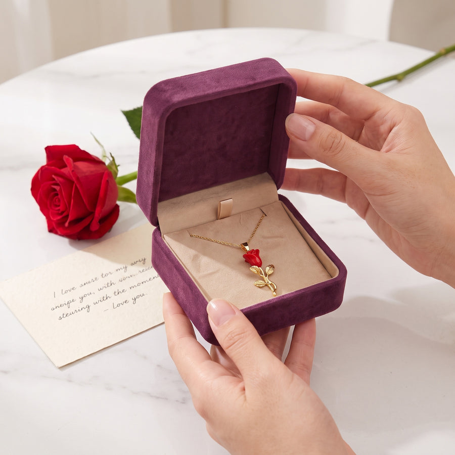 Hands opening the Storyelle plum velvet gift box with the Enchanted Rose necklace