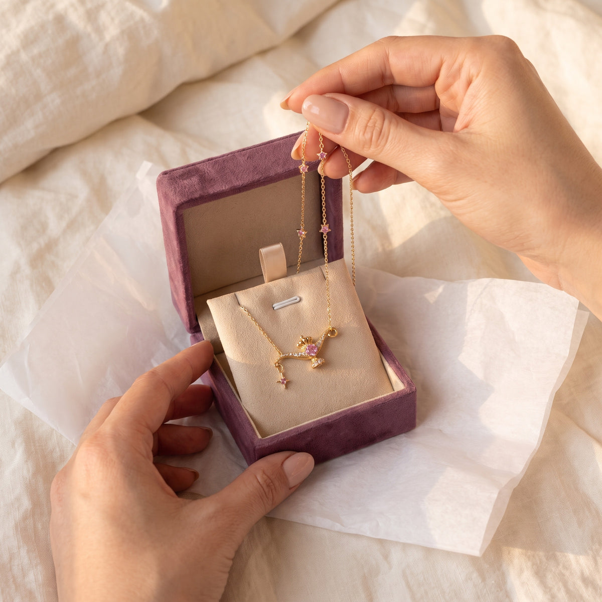 Hands opening the Storyelle gift box with the Wish Lamp necklace