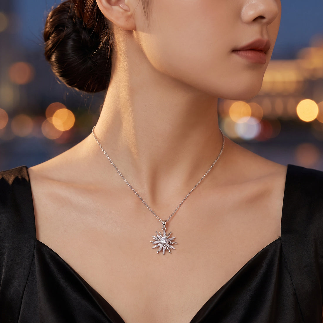 Woman in a black dress wearing the Rapunzel Spinning Silver sun necklace