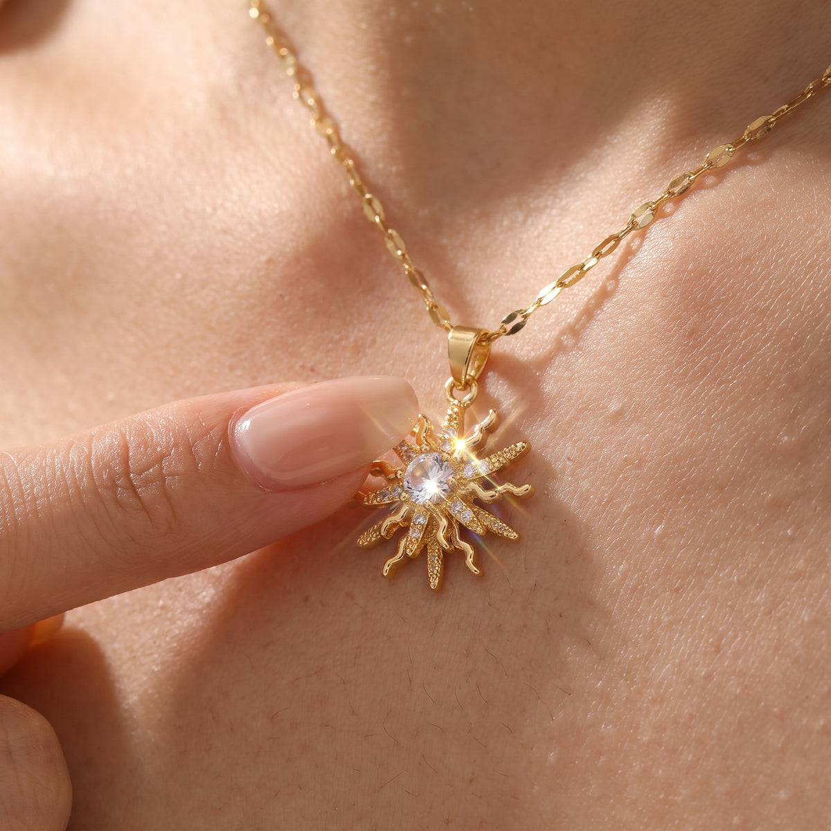 Fingertip spinning the center of the Rapunzel Spinning Gold sun pendant