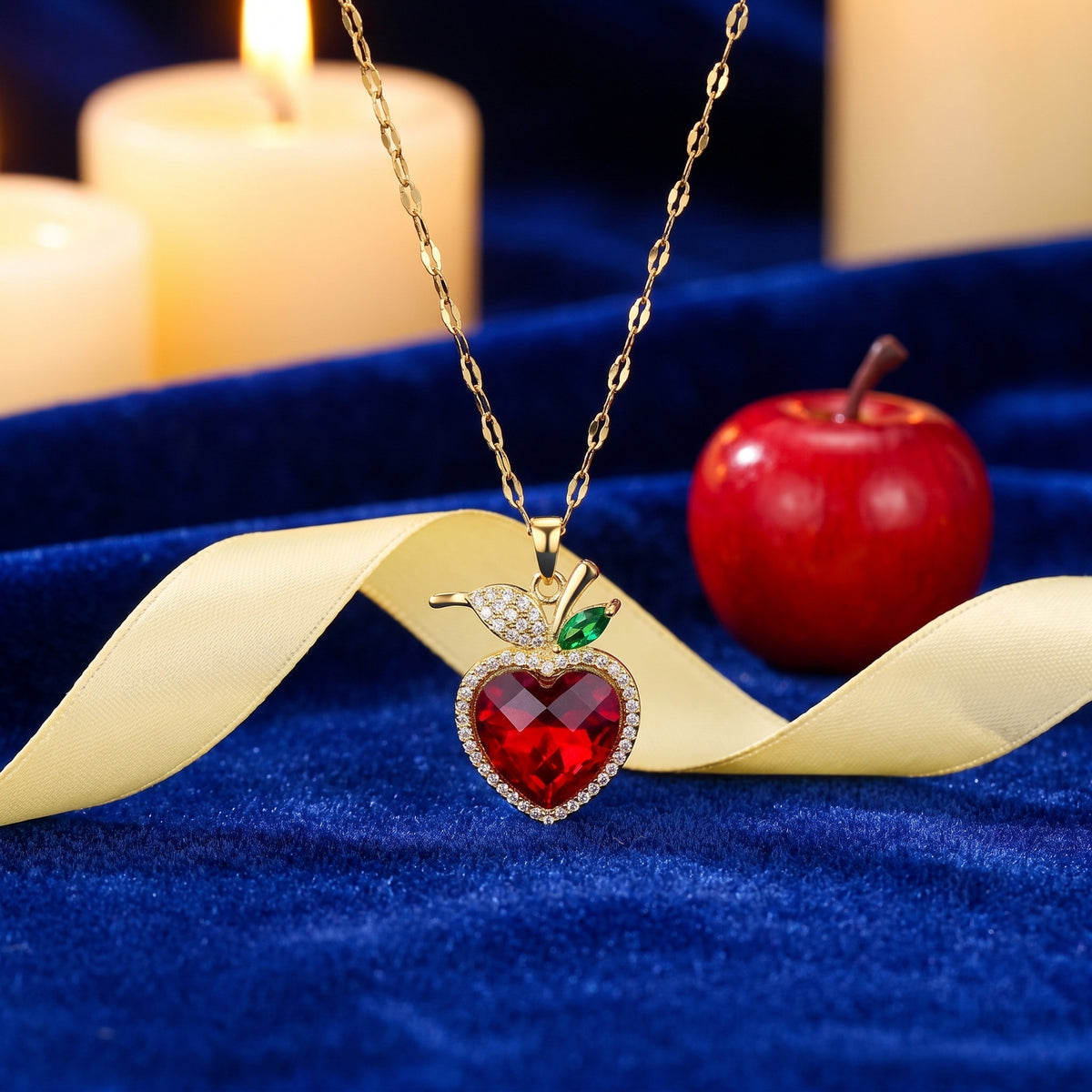 The Crimson Heart necklace on royal blue velvet with a yellow ribbon and a red apple