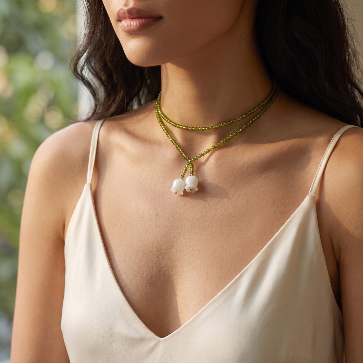 Woman wearing the Tiana Emerald Lily necklace wrapped as a choker